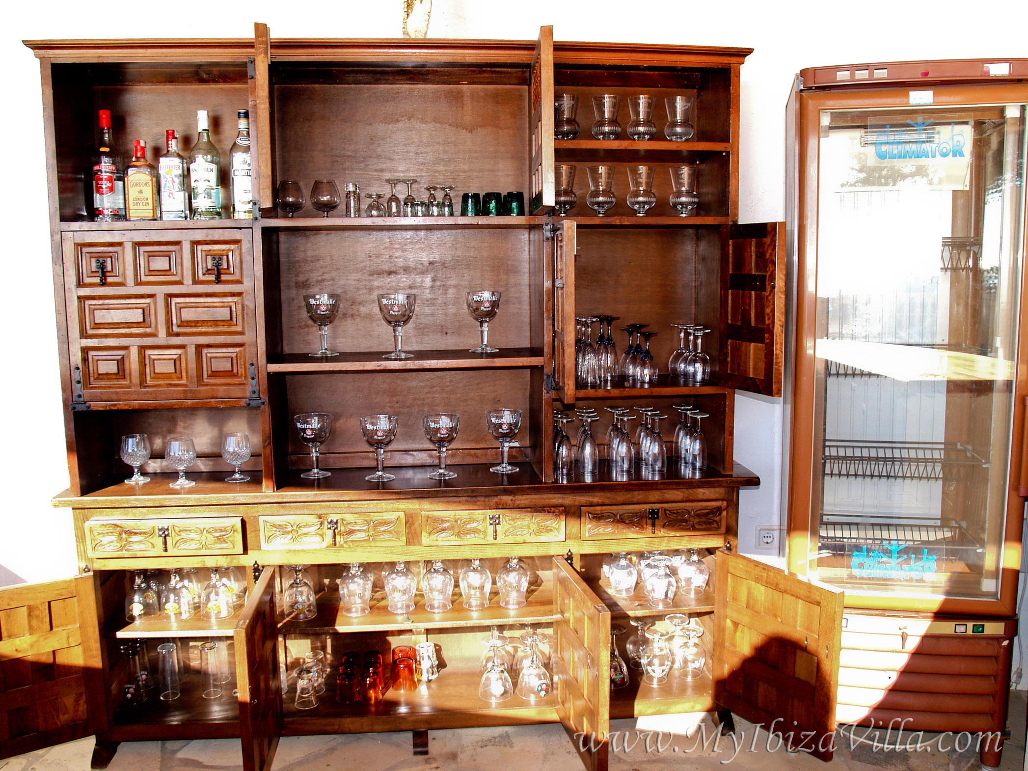 Cupboard with great variety of glasses behind the bar.