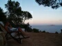 Leatitia reads a book in the deck-chair while the reddish light of the sunset shines on her face.